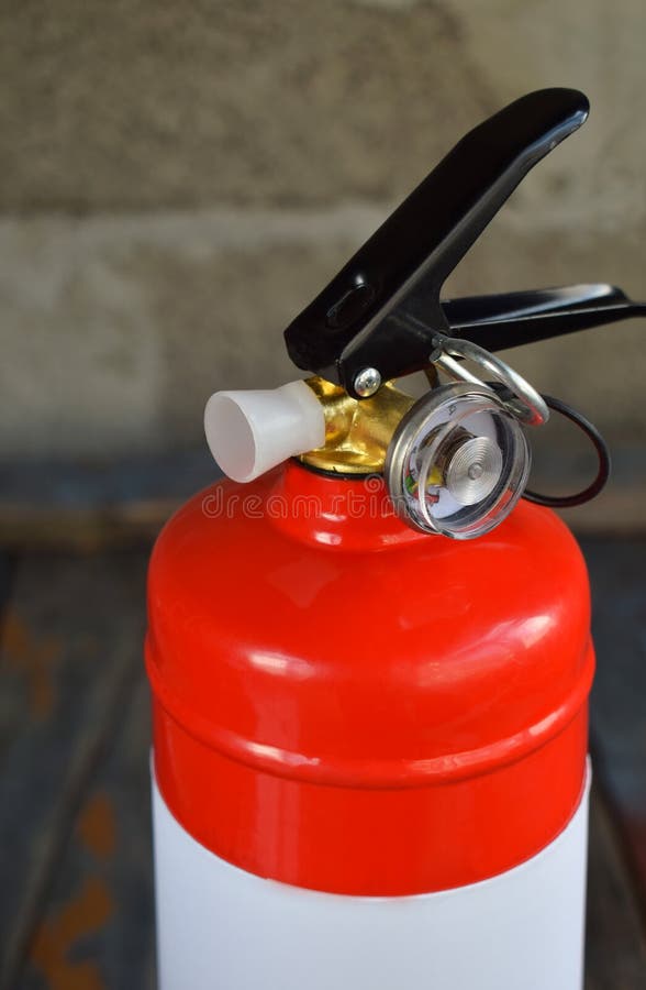 Compact Red Fire Extinguisher for Auto or Home on Grey Background. for Fire Emergencies. Stock