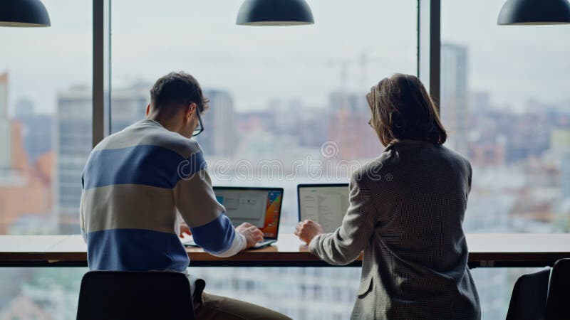 Compagni di squadra che lavorano con la chiusura di coworking panoramico. Uomo che scrive portatili archivi video