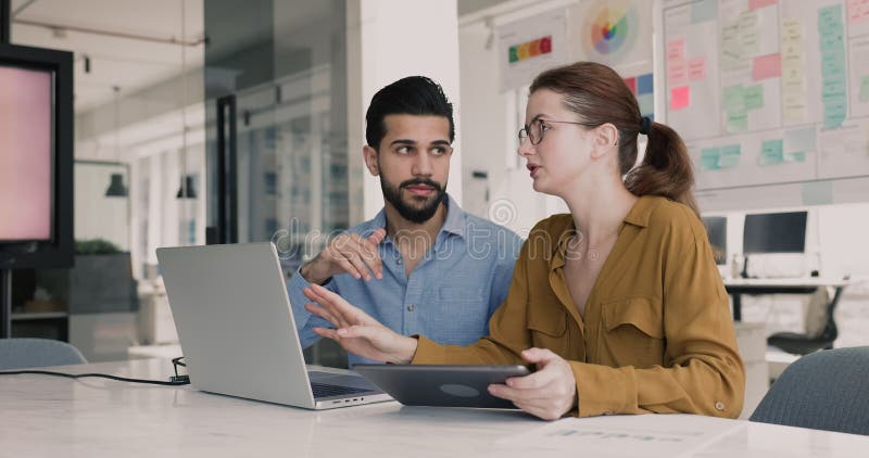 Compagni di squadra che utilizzano laptop e tablet digitali stock footage