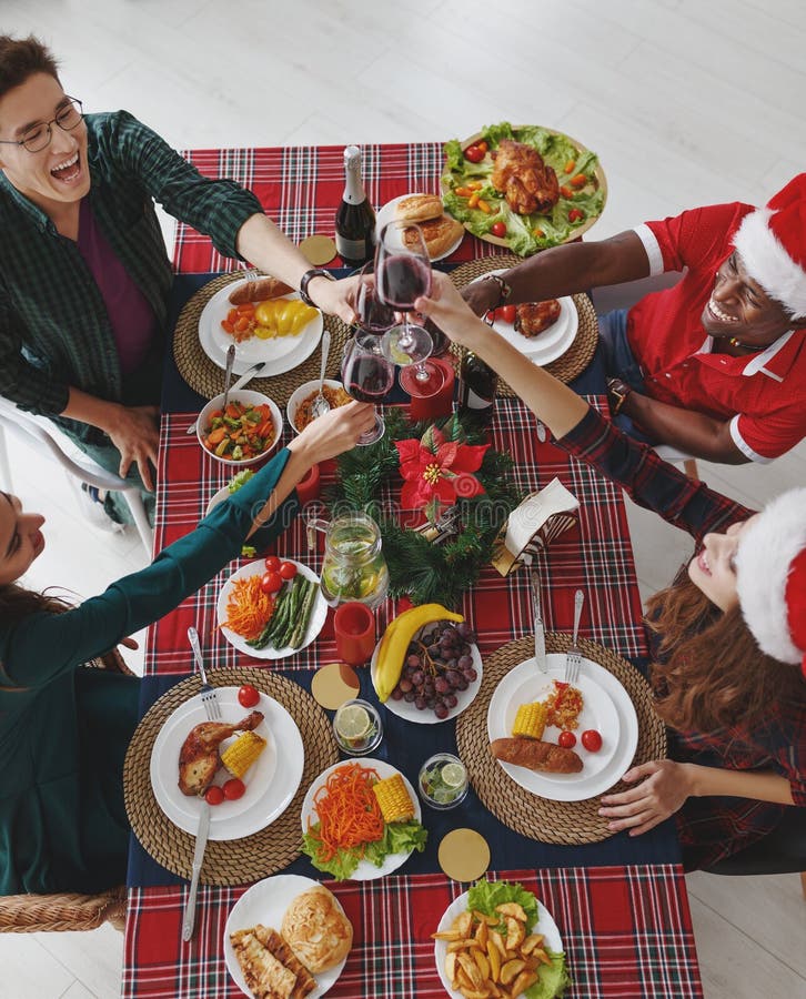 Company of cheerful and happy friends celebrating at the christmas dinner