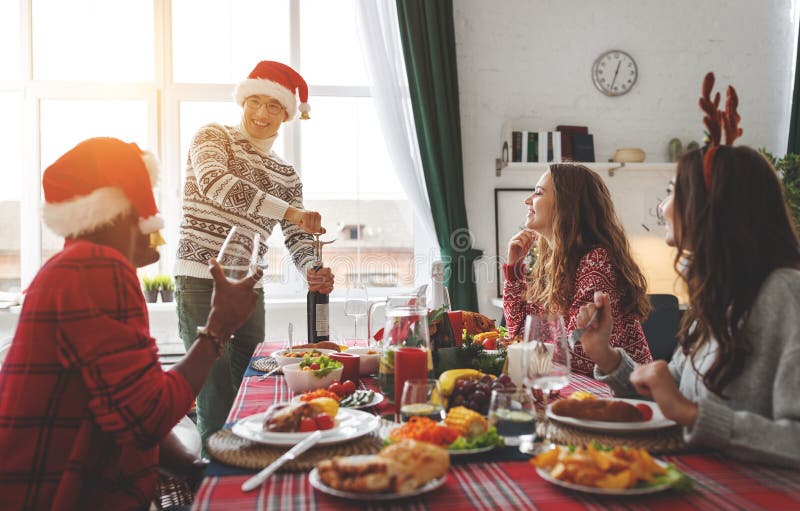 Company of cheerful and happy friends celebrating at the christmas dinner