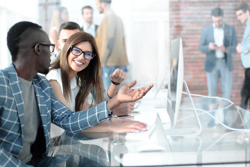 Company Employees Discussing Work Issues at the Desk Stock Photo