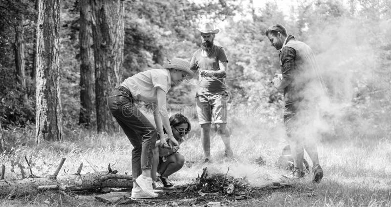 Company friends or family making bonfire in forest nature background. Friends working as team to keep bonfire. Company royalty free stock photography Company friends or family making bonfire in forest nature background. Friends working as team to keep bonfire. Company royalty free stock photography