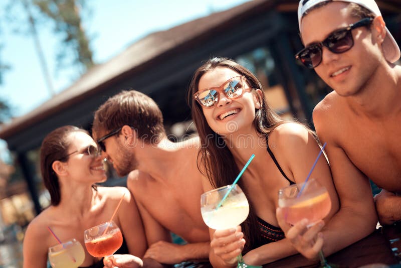 Company of happy friends drinks cocktail drinks in swimmingpool at summertime. Swimming pool party. stock photo Company of happy friends drinks cocktail drinks in swimmingpool at summertime. Swimming pool party. stock photo
