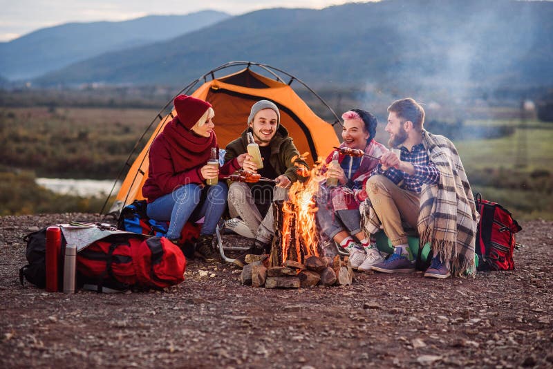 Company of young friends having a picnic by the mountains, they are chatting, laughing, drinking energy drink and bake stock photography Company of young friends having a picnic by the mountains, they are chatting, laughing, drinking energy drink and bake stock photography