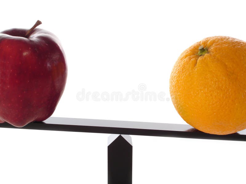 Comparing apples to heavy oranges on a balance beam isolated on white close-up. Comparing apples to heavy oranges on a balance beam isolated on white close-up.