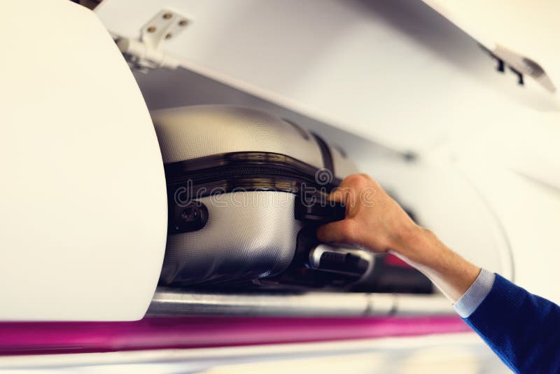 compartimento da Mão-bagagem com as malas de viagem no avião As mãos decolam a bagagem de mão O passageiro pôs a cabine do saco d imagens de stock compartimento da Mão-bagagem com as malas de viagem no avião As mãos decolam a bagagem de mão O passageiro pôs a cabine do saco d imagens de stock