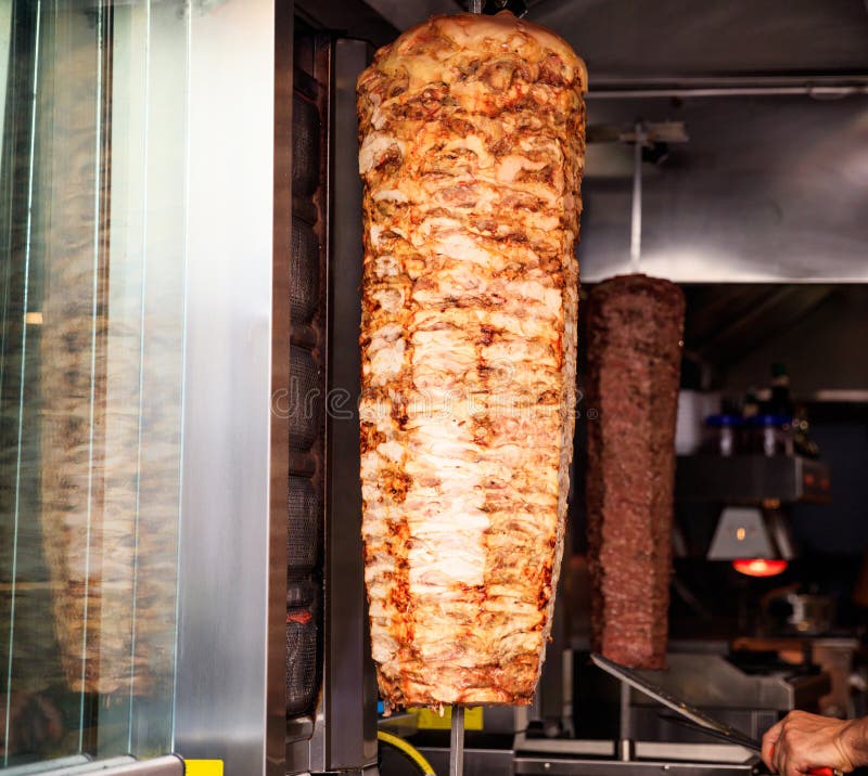 Gyros, doner grilled slowly on rotating spit. Blurred background. Gyros, doner grilled slowly on rotating spit. Blurred background.