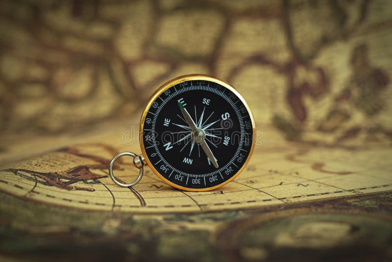 Compass on blur vintage map background, retro color tone, direction journey planning concept, blank space, top view stock photography Compass on blur vintage map background, retro color tone, direction journey planning concept, blank space, top view stock photography