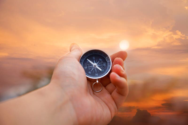 Hand holding the compass in sunset. Hand holding the compass in sunset