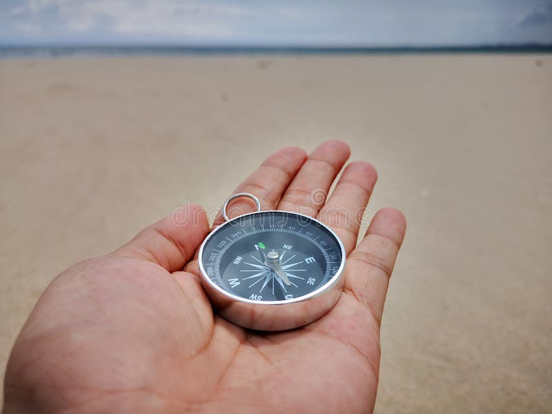 A Boy Holding A Compass Showing The Direction Point To North Facing The