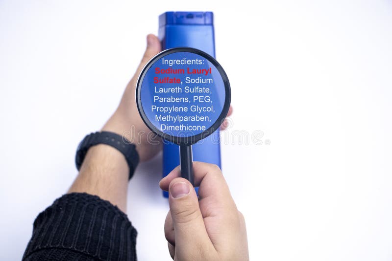 Componentes químicos en la etiqueta de champú: Sulfato de sodio Lauryl, sarampión, sarna Una mano sostiene un frasco azul y una l
