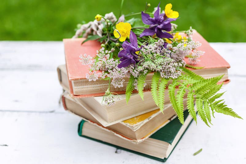 Composici?n del vintage del verano Libros viejos, un ramo de flores salvajes en un fondo rústico foto de archivo Composici?n del vintage del verano Libros viejos, un ramo de flores salvajes en un fondo rústico foto de archivo