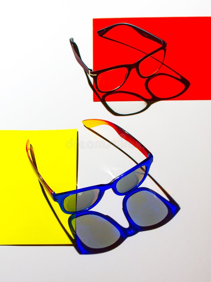 Composición abstracta de gafas de sol en las cartulinas coloridas y el fondo blanco imagen de archivo libre de regalías Composición abstracta de gafas de sol en las cartulinas coloridas y el fondo blanco imagen de archivo libre de regalías