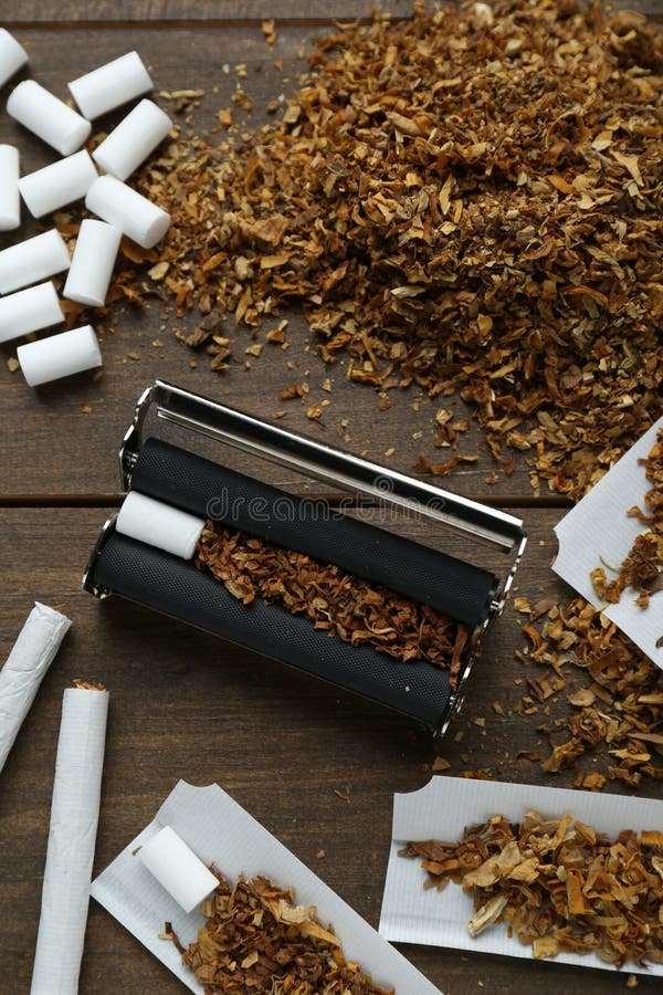 Flat lay composition with roller and tobacco on table. Making hand rolled cigarettes. Flat lay composition with roller and tobacco on table. Making hand rolled cigarettes