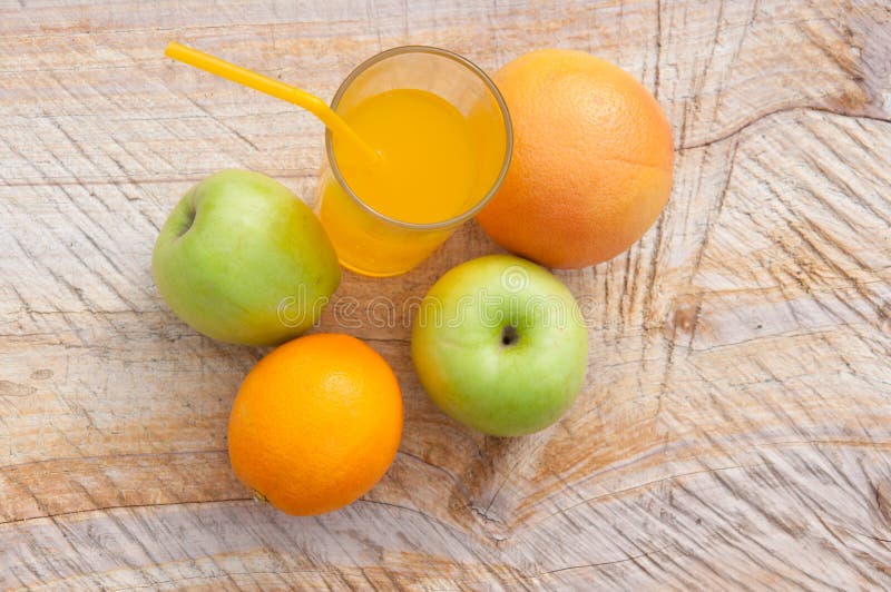 Composición del jugo fresco en vidrio y frutas transparentes en fondo de madera foto de archivo Composición del jugo fresco en vidrio y frutas transparentes en fondo de madera foto de archivo