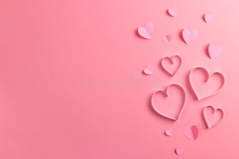 Composición para el Día de San Valentín 14 de febrero Delicado fondo rosa y corazones rosados cortados de papel Tarjeta de felici