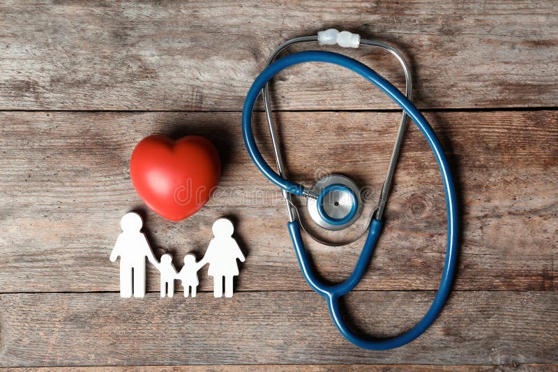 Composición puesta plana con la figura del corazón, del estetoscopio y de la familia en fondo de madera fotografía de archivo Composición puesta plana con la figura del corazón, del estetoscopio y de la familia en fondo de madera fotografía de archivo