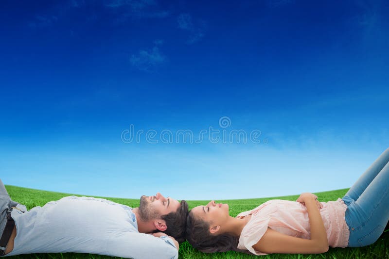Composite image of attractive young couple lying down stock images Composite image of attractive young couple lying down stock images