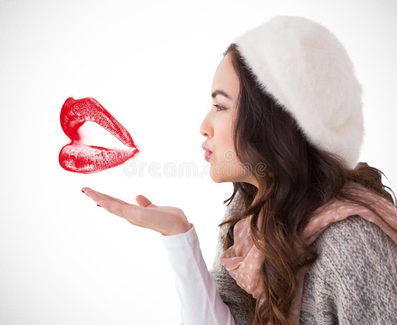 Brunette in winter clothes blowing kiss against white background with vignette. Winter woolen clothes stock images, royalty-free photos and pictures
