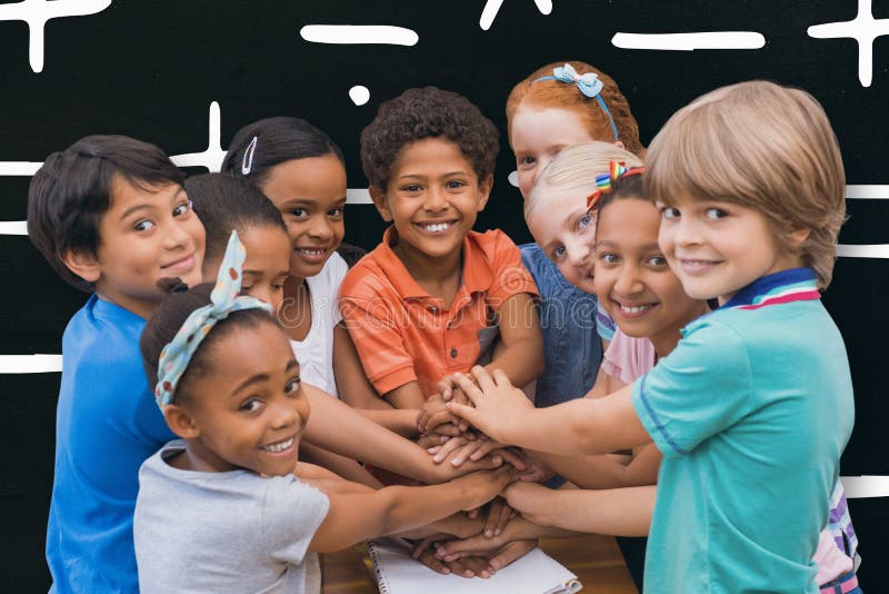 Composite image of cute pupils smiling at camera in classroom stock photography