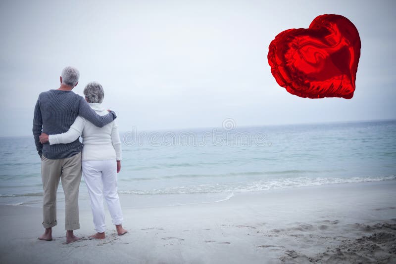 Composite image of senior couple on beach and red heart balloon 3d