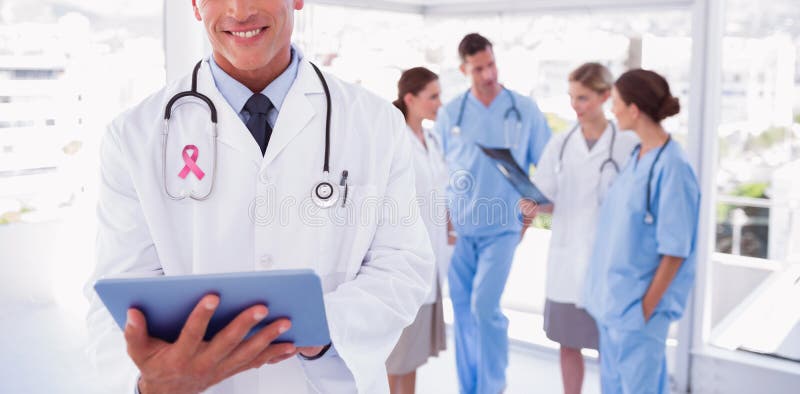 Composite image of smiling doctor holding digital tablet stock image Composite image of smiling doctor holding digital tablet stock image
