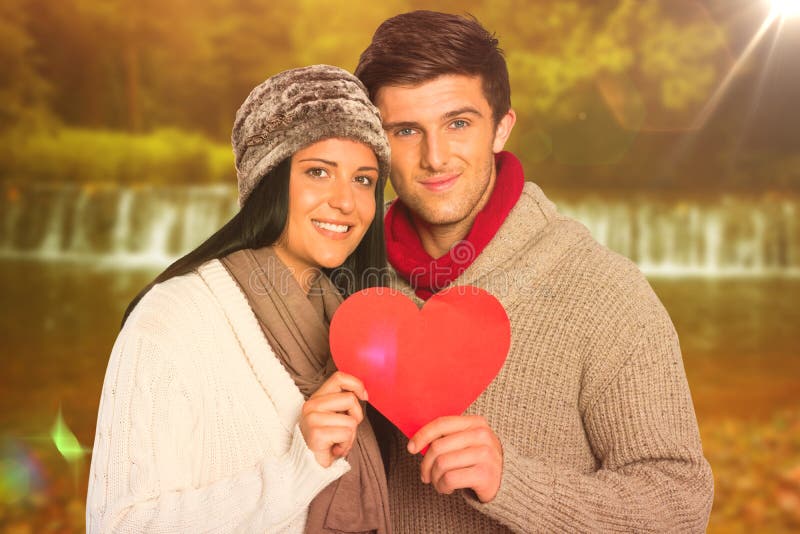 Composite image of young couple smiling holding red heart stock photos Composite image of young couple smiling holding red heart stock photos