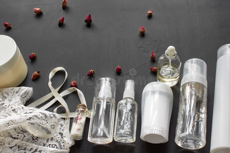 Composition avec les produits cosm?tiques de soins de la peau sans label et lingerie blanche sur un fond de bureau noir photos libres de droits Composition avec les produits cosm?tiques de soins de la peau sans label et lingerie blanche sur un fond de bureau noir photos libres de droits