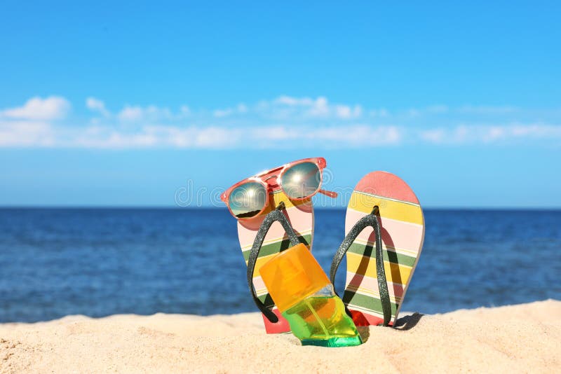 Composition with beach accessories on sand near sea in summer