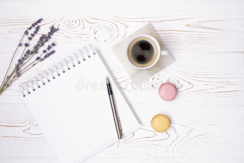Composition from blank diary, cup of coffee and macaroon and lavender flowers on a white shabby wooden table. Fashion flat lay royalty free stock photography Composition from blank diary, cup of coffee and macaroon and lavender flowers on a white shabby wooden table. Fashion flat lay royalty free stock photography