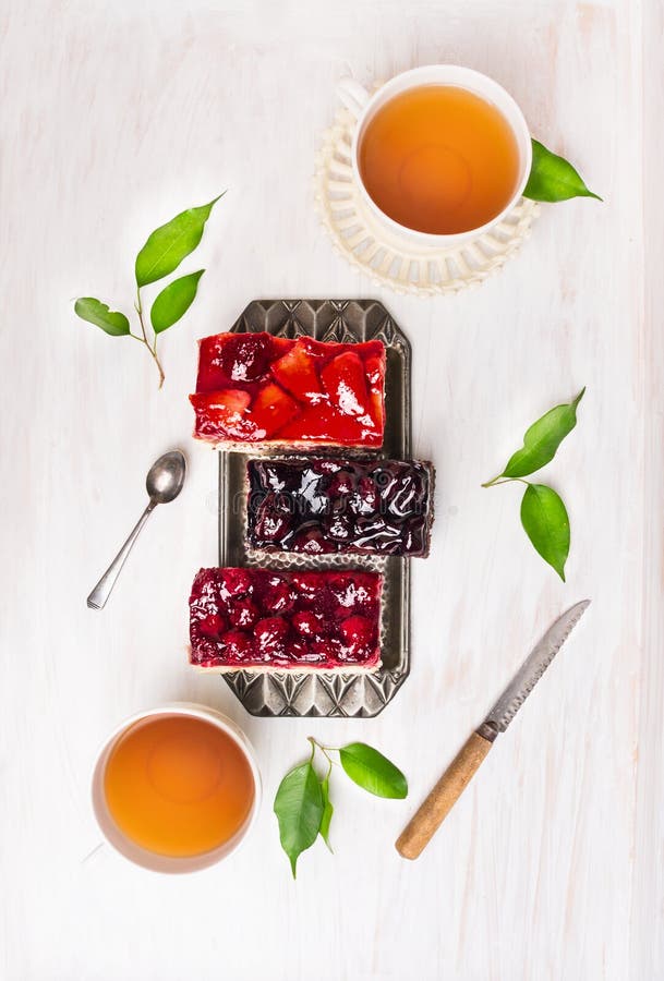 Composition of cakes with different fruit and a cup of tea