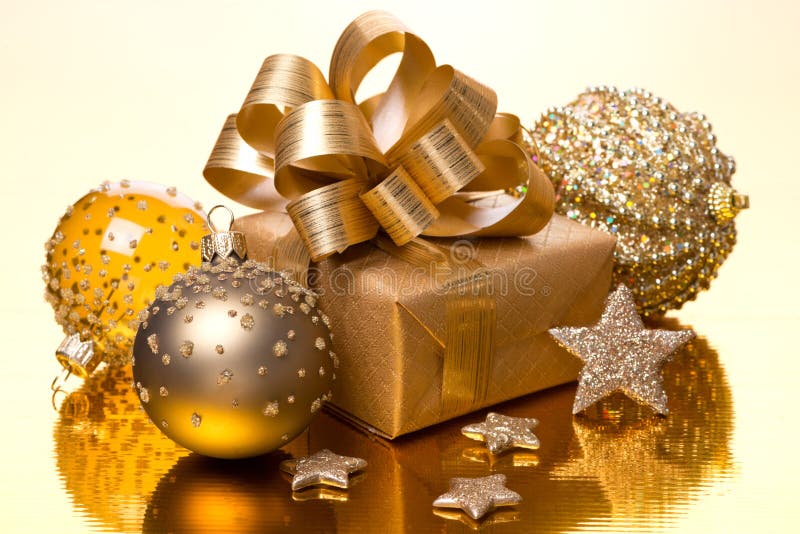 Composition with Christmas balls and gift box on golden table