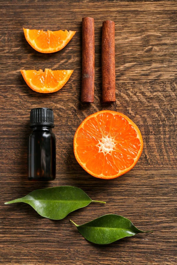 Composition with citrus essential oil, cinnamon sticks and orange slices on wooden table, top view stock image Composition with citrus essential oil, cinnamon sticks and orange slices on wooden table, top view stock image