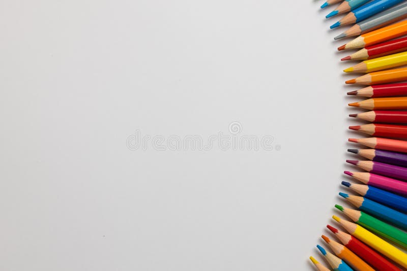 Composition of colorful crayons and other school tools on white surface with copy space. School equipment, tools, learning and creativity concept.