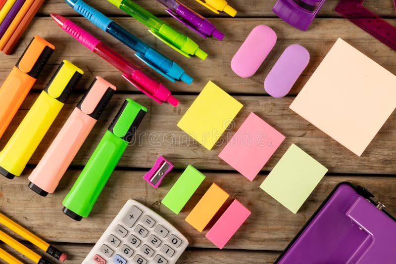 Composition of colorful crayons, pens, markers and other school tools on wooden surface. School equipment, tools, learning and creativity concept.