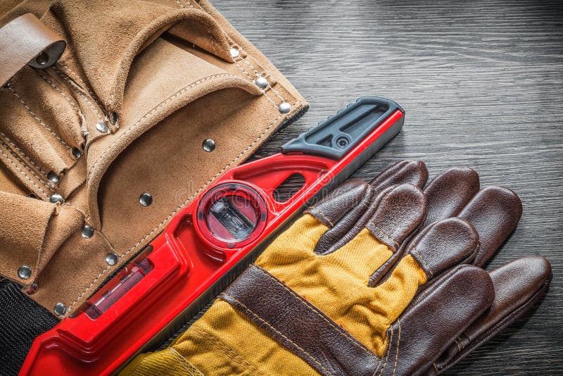 Composition of construction level working gloves leather tool belt on wooden board. Pair working gloves stock images, royalty-free photos and pictures