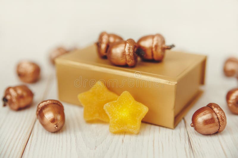 Composition de Noël Boîte actuelle d'or et glands d'or Table en bois blanche, étoiles de jujube image stock Composition de Noël Boîte actuelle d'or et glands d'or Table en bois blanche, étoiles de jujube image stock