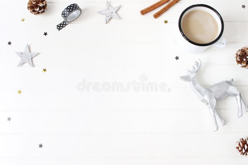 Composition de Noël Chocolat chaud, cônes de pin, bâtons de cannelle, étoiles confettis et renne sur le fond blanc de table photo stock Composition de Noël Chocolat chaud, cônes de pin, bâtons de cannelle, étoiles confettis et renne sur le fond blanc de table photo stock