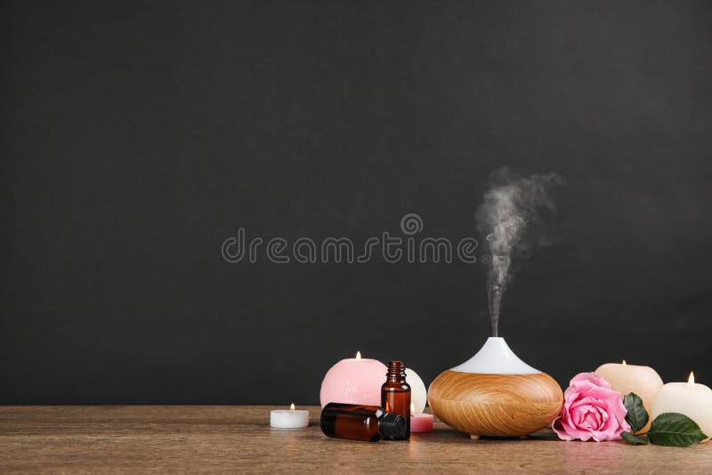 Composition with essential oils diffuser on table against black background stock photo