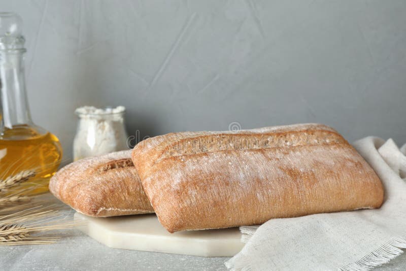 Composition with fresh crispy ciabattas on grey table