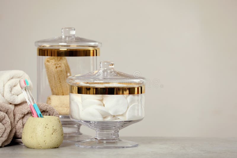 Composition of Glass Jar with Cotton Pads on Table Near Light Wall