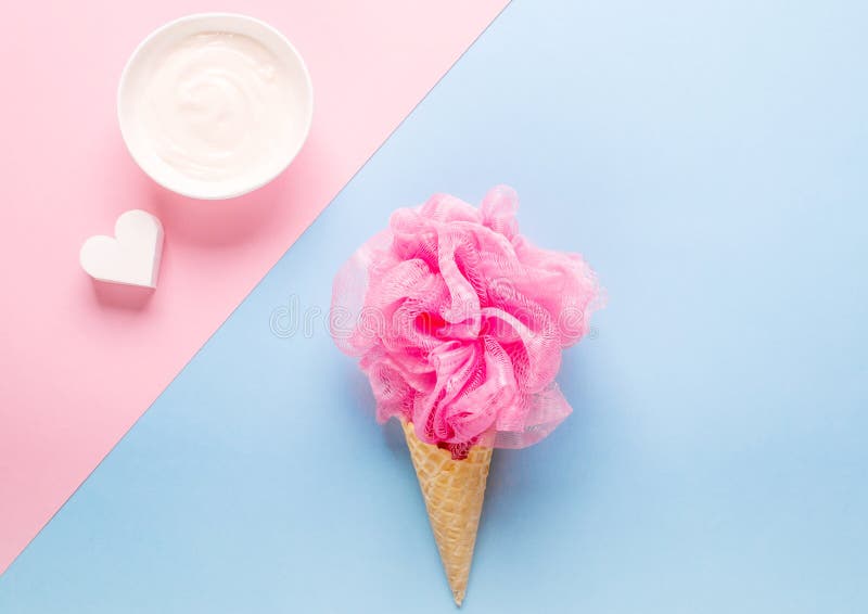 Composition of ice cream cone with pink wisp of bast on a light blue background royalty free stock images Composition of ice cream cone with pink wisp of bast on a light blue background royalty free stock images