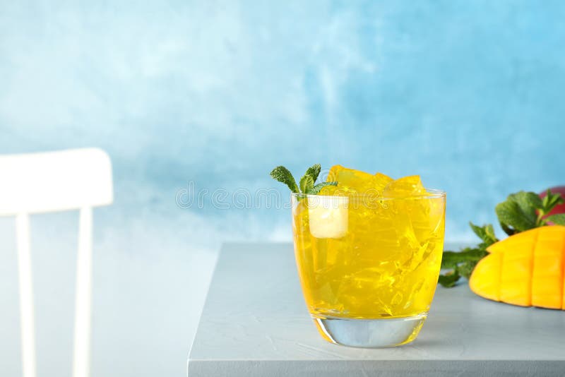 Composition with mango jelly in glass on table against color background stock photography Composition with mango jelly in glass on table against color background stock photography