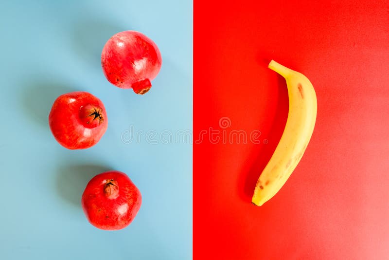 Composition with symmetrical red and blue background, and some contrast pomegranate fruits.