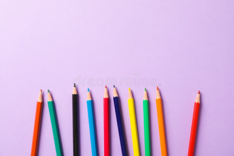 Composition étendue plate avec les crayons multicolores sur le fond violet photos stock Composition étendue plate avec les crayons multicolores sur le fond violet photos stock
