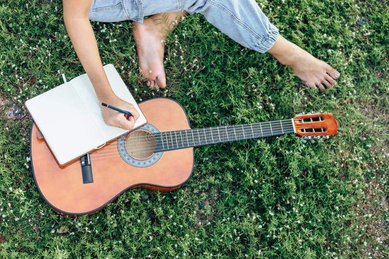 Compositor crea y escribe notas en la hierba del libro en parques fotografía de archivo libre de regalías