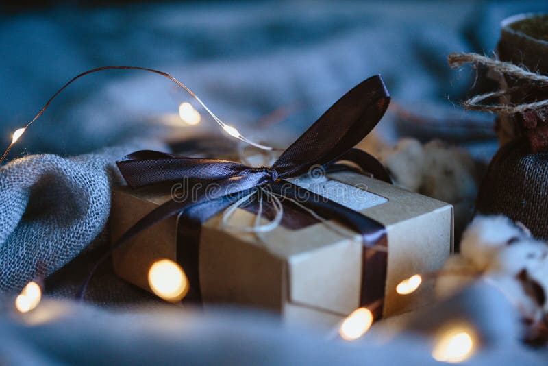 Composizione accogliente in inverno con i regali di eco e le luci di natale, disposizione piana, falsa su immagine stock Composizione accogliente in inverno con i regali di eco e le luci di natale, disposizione piana, falsa su immagine stock