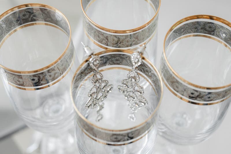 Composizione degli orecchini della sposa sui vetri alla moda d'annata fotografie stock Composizione degli orecchini della sposa sui vetri alla moda d'annata fotografie stock
