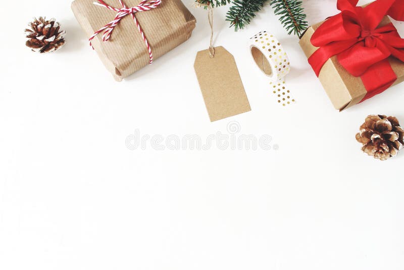 Composizione in natale Pagina dei rami di albero dell'abete, pigne, contenitori di regalo di natale, etichetta, nastro dorato di fotografie stock Composizione in natale Pagina dei rami di albero dell'abete, pigne, contenitori di regalo di natale, etichetta, nastro dorato di fotografie stock